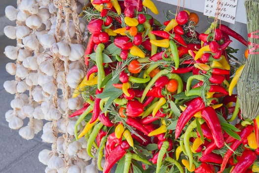 Organic garlics hanging and fresh chili  pepper in a market place