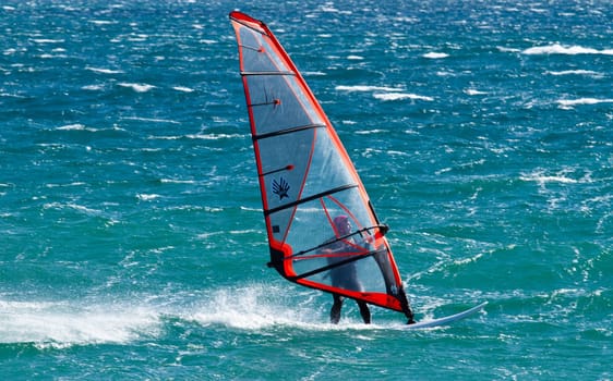 young man surfing the wind on summer day