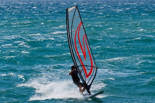 young man surfing the wind on summer day