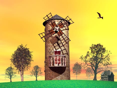 Old windmill in the countryside among trees and next to a small house by sunset