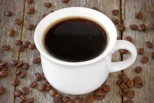 cup of coffee and coffee-beans  on wood background
