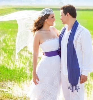 Couple in wedding day outdoor with wind on veil