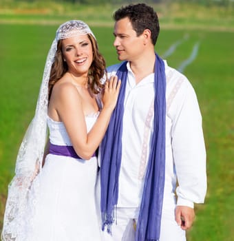 Couple in wedding day hug in outdoor green meadow