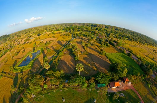Fisheye aerial view of Cambodian countryside with Angkor Wat visible near horizon