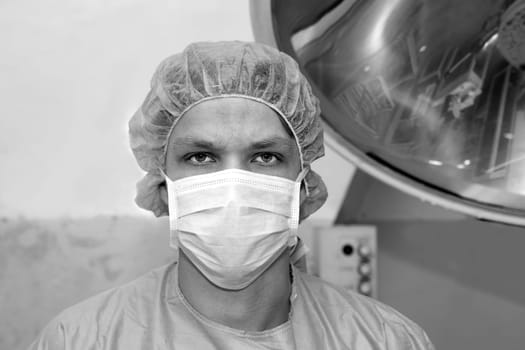 Shaded surgeon seems serious about coming difficult surgery