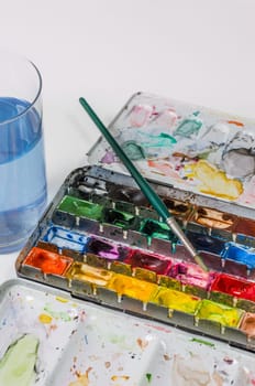Watercolor paint box with brush and water glass