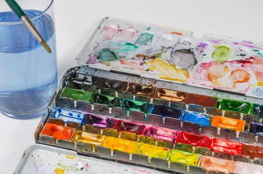 Watercolors with brush and water glass