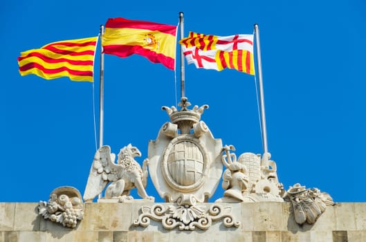 Flags waving in the city of Barcelona Spain. Detail of the shield of the city.