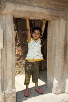 Tiny little girl pretending to lift the upper door slab