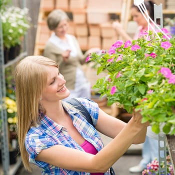 Young woman shopping flowers at market garden centre