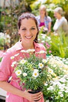 Woman hold potted daisy white flower at garden shopping center