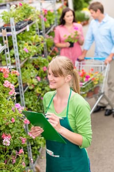 Happy florist woman make inventory at garden shopping center