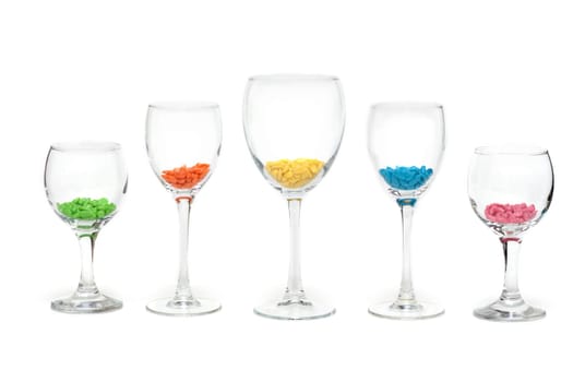 Tall wine glasses exposed in row on white background with colour sweetmeat
