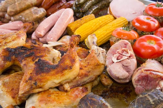 Assorted pieces of grilled vegetables, meat and chicken ready for sale at a farmer's market.