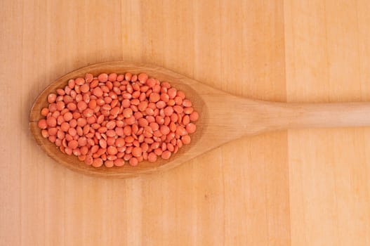 Close-up wooden spoon with red lentils