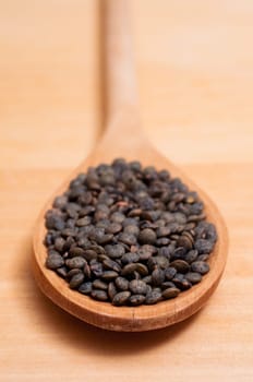 Close-up of dark Alb lenses on a wooden spoon