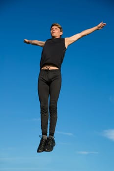 Sportsman jump at high above the greeny ground