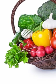 Composition with raw vegetables in a wicker basket. Isolated on white background