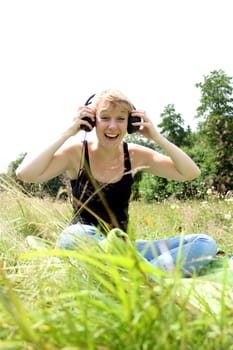 girl on meadow with headphones