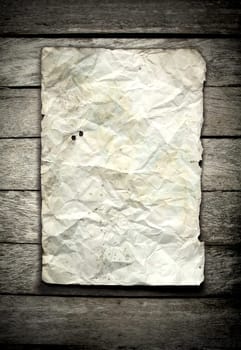old crumpled paper on wooden wall
