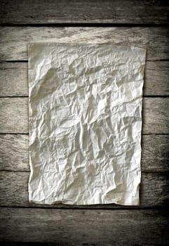 old crumpled paper on wooden wall