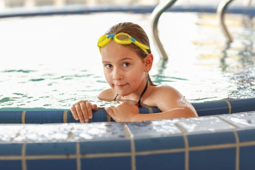 Cute child with goggles relaxing at whirlpool