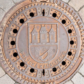 Rusty manhole on the pavement in Prague