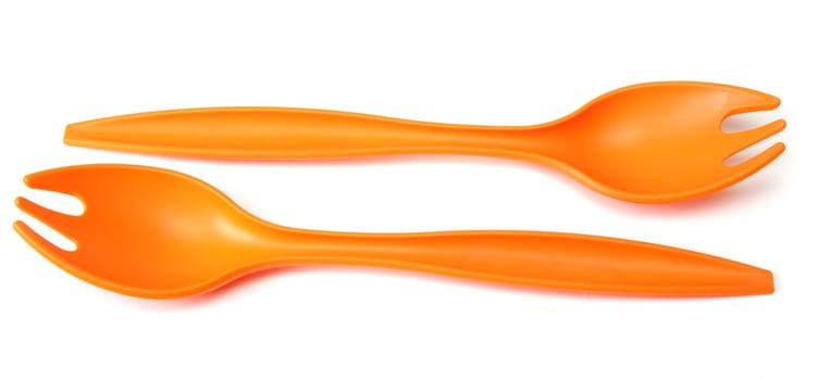 Two plastic orange forks on white background