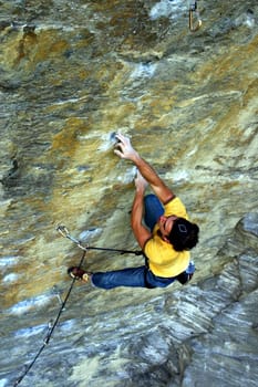 Strong free climber climbing a hard wall