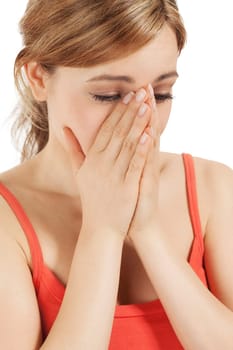 Crying young blonde woman with hands in front of her face