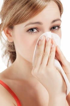 Young blonde woman with hay fever and a handkerchief