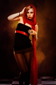 Mystical beautiful woman with red cloth with smoke in the background