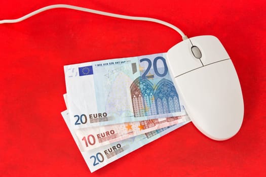 Making money online concept. Computer mouse and money on red background.