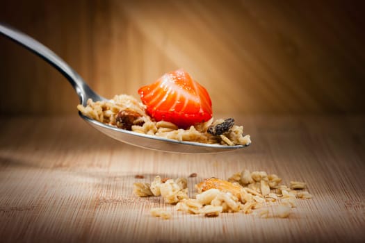 Close up image of granola and fruit on a spoon