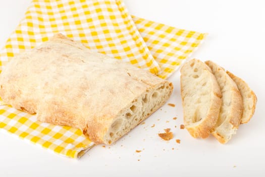 Sliced ciabatta bread on a checkered tablecloth