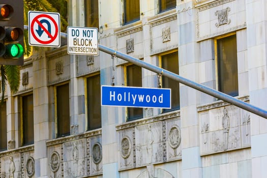 Hollywood Blvd street sign with tall palm trees.