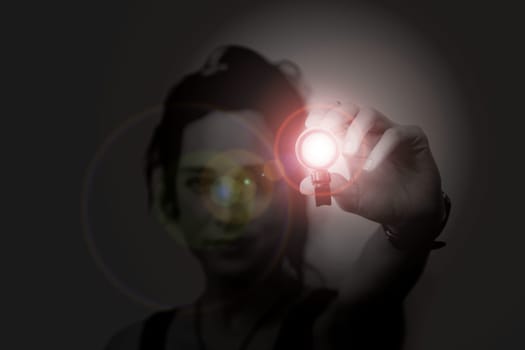 young woman holding a led flashlight at night