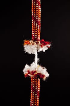 A red rope is breaking on a black background