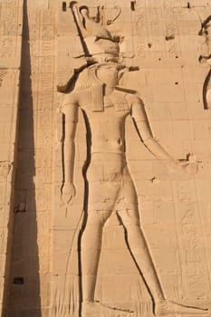 Carving of Egyptian god on pylon in Temple of Phylae near Aswan (Nubia, Egypt)