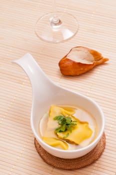 Maultaschen soup and pretzel stick and a wine glass