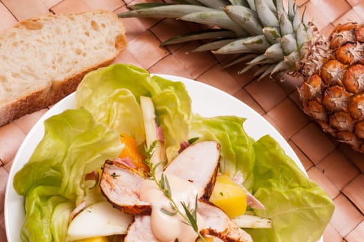 Salad with poultry and fruit on a plate