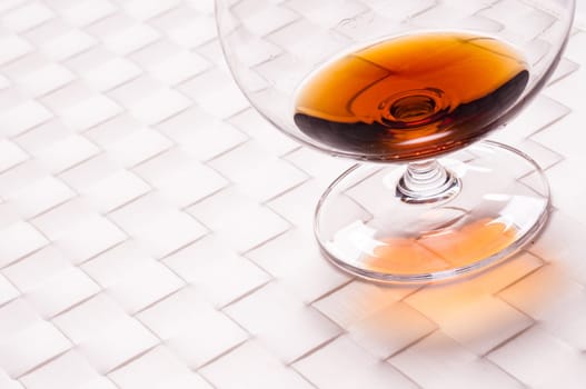Brown brandy in a glass on a white background