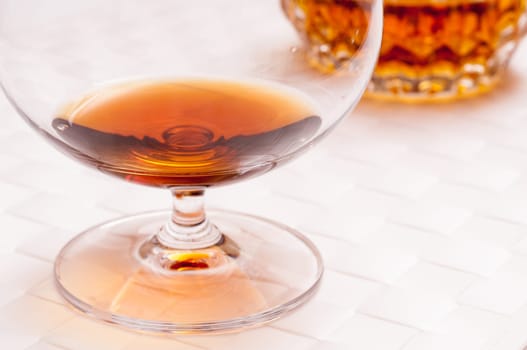 Brown brandy in a cognac swirl on a white background