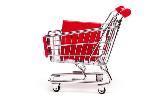 Shopping cart with red gift on white background
