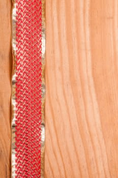 Wooden board with gold and red ribbon as background