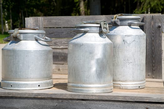 Three different sizes milk cans on scaffold