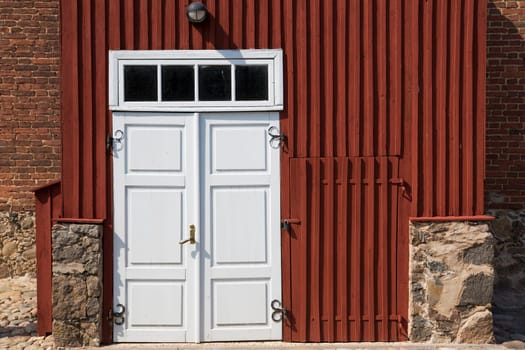 Wooden door in front of stony brick house