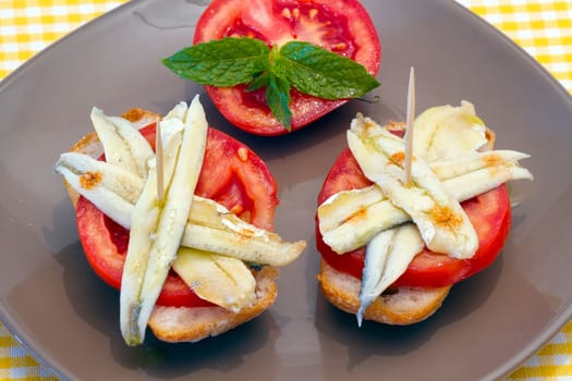 skewer of pickled anchovies, adorned with tomato and mint, cover typical Spanish