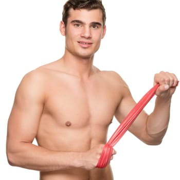 Young man with a red gymnastics band against a white studio background