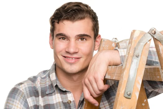 Young man leaning on a ladder against white studio background